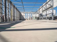 large indoor structure with lots of windows, green pipe, and white pipes on the ground