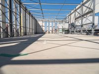 large indoor structure with lots of windows, green pipe, and white pipes on the ground