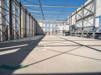 large indoor structure with lots of windows, green pipe, and white pipes on the ground