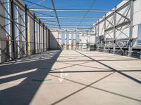 large indoor structure with lots of windows, green pipe, and white pipes on the ground