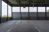 the empty area in a building with steel railings and windows and a gray concrete wall with a blue sky