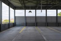 the empty area in a building with steel railings and windows and a gray concrete wall with a blue sky