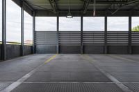 the empty area in a building with steel railings and windows and a gray concrete wall with a blue sky