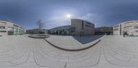 two cameras are reflecting the sun in this city square area of a university campus's courtyard