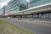 there is a street in front of buildings with lots of windows and grass on it