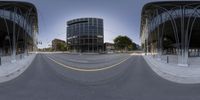 a 360 view of a big street next to buildings and street lamps with a large glass building in the background