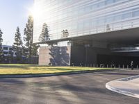 a person riding a skateboard down a road next to a building and trees by itself