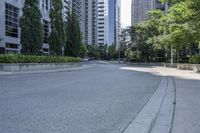 a car driving down an empty street lined with tall buildings and trees in the background