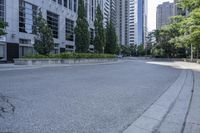 a car driving down an empty street lined with tall buildings and trees in the background