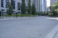 a car driving down an empty street lined with tall buildings and trees in the background