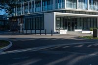 an intersection with a building behind it and a person waiting in the parking space on a sidewalk