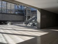 a large empty walkway with glass doors and escalators in front of it on an empty building