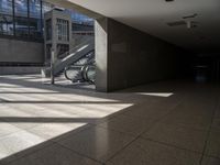 a large empty walkway with glass doors and escalators in front of it on an empty building