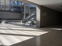 a large empty walkway with glass doors and escalators in front of it on an empty building