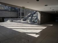 a large empty walkway with glass doors and escalators in front of it on an empty building