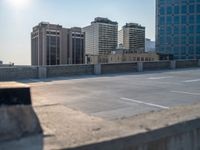 several large empty parking spaces in the city with buildings nearby in front of them -