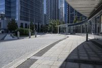 a person sitting at the bench in front of a mall that is empty of people