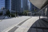 a person sitting at the bench in front of a mall that is empty of people