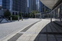 a person sitting at the bench in front of a mall that is empty of people