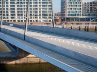 view of a bridge crossing across a river next to a large city with tall buildings