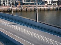 view of a bridge crossing across a river next to a large city with tall buildings