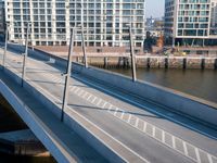 view of a bridge crossing across a river next to a large city with tall buildings