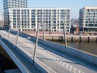 view of a bridge crossing across a river next to a large city with tall buildings