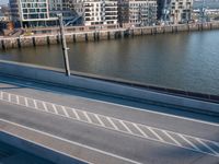 view of a bridge crossing across a river next to a large city with tall buildings