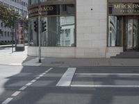 a crosswalk on the street that is close to a tall building with many windows