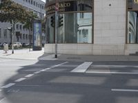 a crosswalk on the street that is close to a tall building with many windows