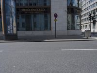 a crosswalk on the street that is close to a tall building with many windows