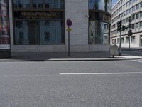 a crosswalk on the street that is close to a tall building with many windows