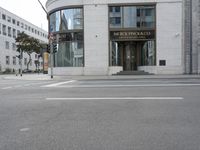 a crosswalk on the street that is close to a tall building with many windows