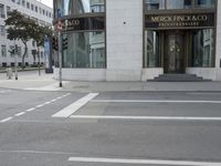 a crosswalk on the street that is close to a tall building with many windows