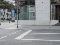 a crosswalk on the street that is close to a tall building with many windows