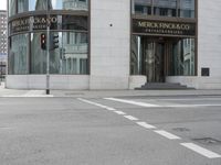 a crosswalk on the street that is close to a tall building with many windows