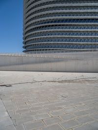 a black fire hydrant is sitting in the concrete area in front of a large building