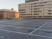 a building sitting in the middle of a parking lot on a street with lines painted in it