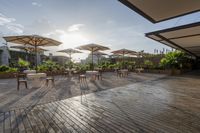 an outdoor patio with tables and chairs and umbrellas for shade and sunlight protection on the area