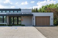 the driveway to the gallery of fine art and presentation galleries is dotted with pavement that runs through the parking lot