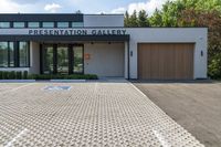 the driveway to the gallery of fine art and presentation galleries is dotted with pavement that runs through the parking lot