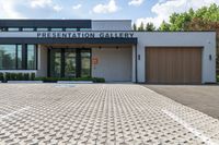 the driveway to the gallery of fine art and presentation galleries is dotted with pavement that runs through the parking lot