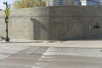 a building is constructed out of concrete on the corner of a street with no traffic