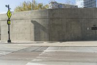 a building is constructed out of concrete on the corner of a street with no traffic