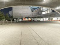 a building has a big concrete structure in the middle of it, with benches and stairs to the side