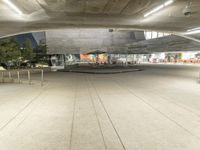 a building has a big concrete structure in the middle of it, with benches and stairs to the side