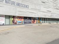 an outdoor picture of the entrance of a science building with advertisement boards in front of it