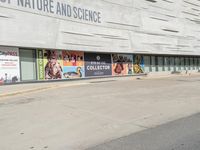 an outdoor picture of the entrance of a science building with advertisement boards in front of it