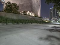 the sidewalk in front of a tall building with buildings along it at night or winter