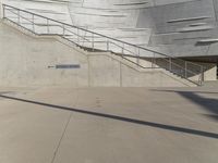 a guy with a skateboard on a sidewalk in front of some stairs and steps